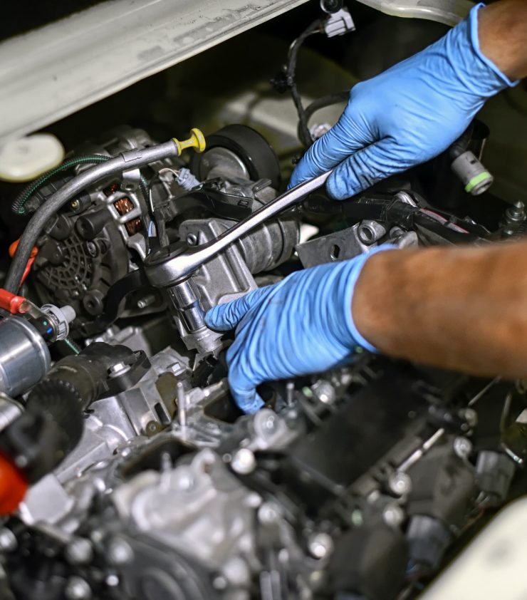 Hands of a mechanic working on a car engine